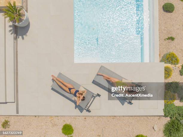 aerial view of friends lounging by pool - outdoor chair stock pictures, royalty-free photos & images