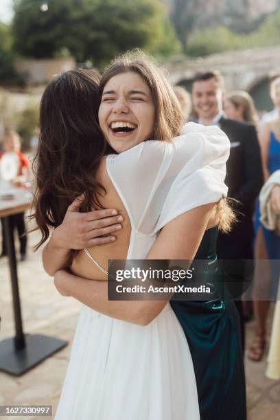 bride and sister embrace at wedding - familys revenge of the bridesmaids stockfoto's en -beelden