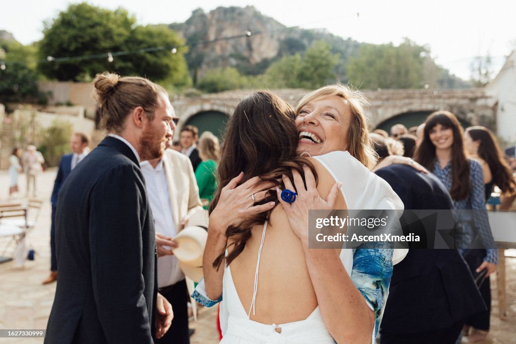 Bride and mother embrace at wedding