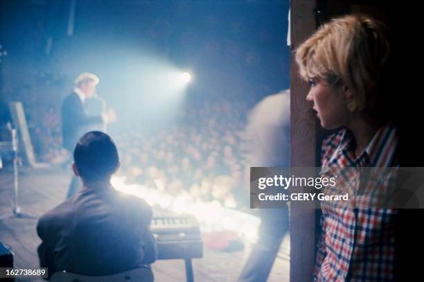 Close-Up Of Sylvie Vartan And Johnny Hallyday. En 1963, lors d'un concert, Sylvie VARTAN en chemise à carreaux dans les coulisses, regardant son...