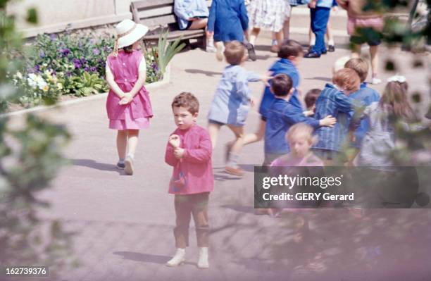 Nicolas Charrier. En mai 1964, dans une cour d'école, Nicolas CHARRIER de face au premier-plan, vêtu d'une blouse rose.