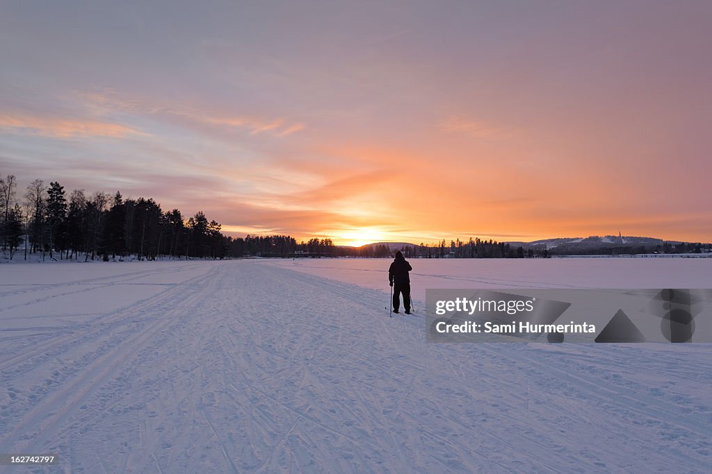A man skiing into the sunset