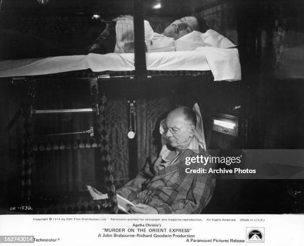 Denis Quilley lies awake while John Gielgud reads in a scene from the film 'Murder On The Orient Express', 1974.