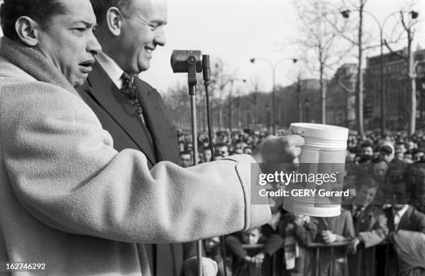 Crusade Against Cancer With Celebrities. En mars 1958, à Paris, le chanteur Henri SALVADOR en croisade contre le cancer, dans la rue, devant un...