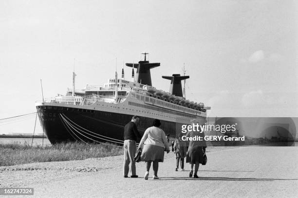 The Liner France. En octobre 1977, des promeneurs sur le quai du Havre ou est amarré le paquebot transatlantique le 'FRANCE' qui vient d'être revendu...