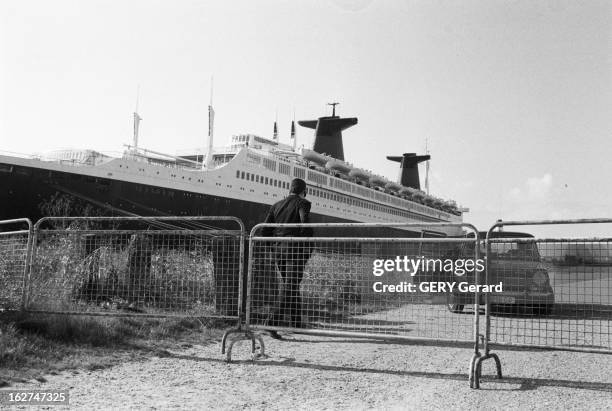 The Liner France. En octobre 1977, une voiture de police avec deux agents devant une barrière de securité, sur le quai du Havre ou est amarré le...