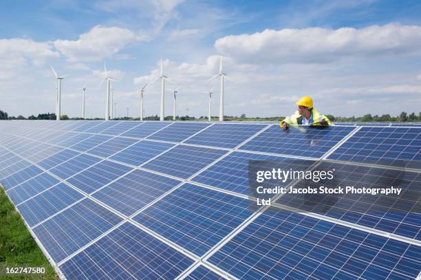 mixed race man checking solar panels - wind power uk stock pictures, royalty-free photos & images