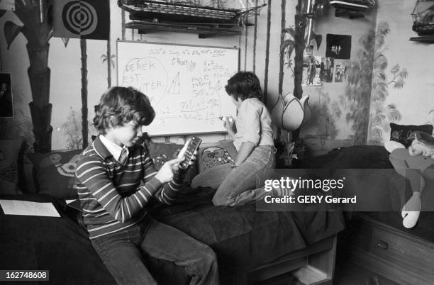 Electronic Calculators. En septembre 1978, deux enfants devant un tableau blanc couvert d'équations mathématiques utilisant une calculatrice...