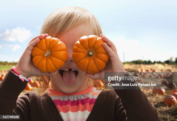 caucasian girl covering eyes with small pumpkins - pick tooth bildbanksfoton och bilder
