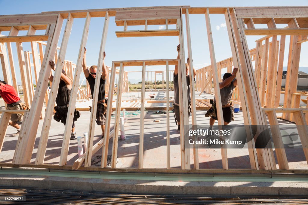 Workers lifting frame on construction site