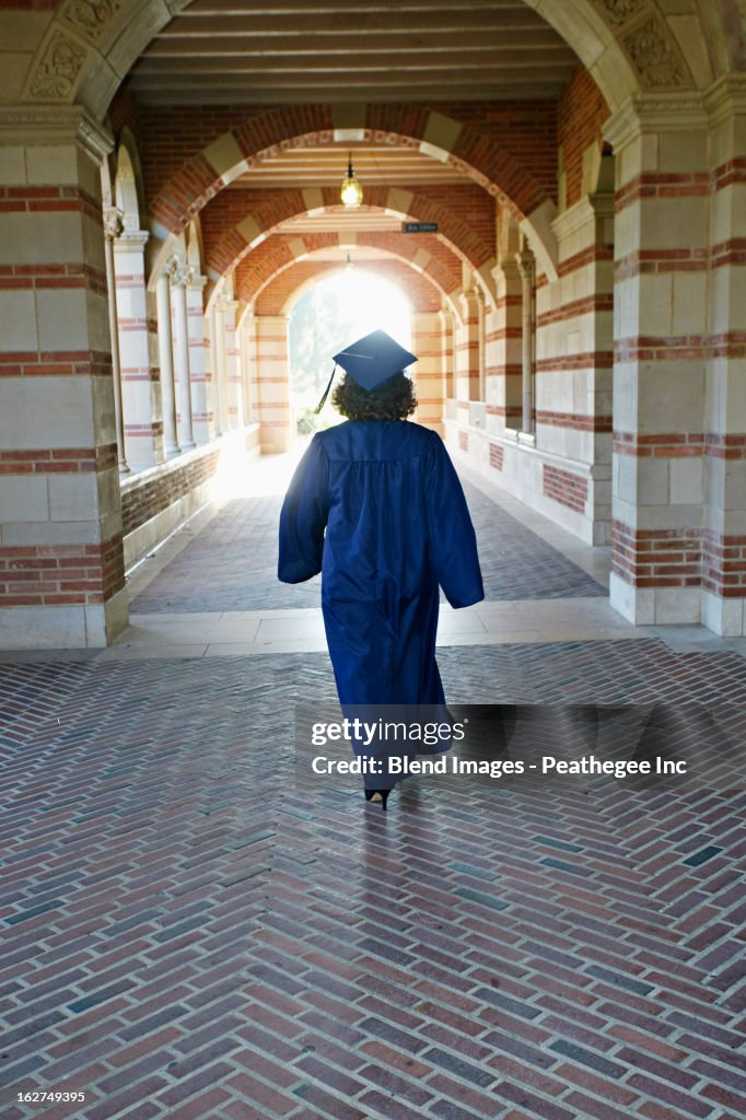 Caucasian graduate walking in portico