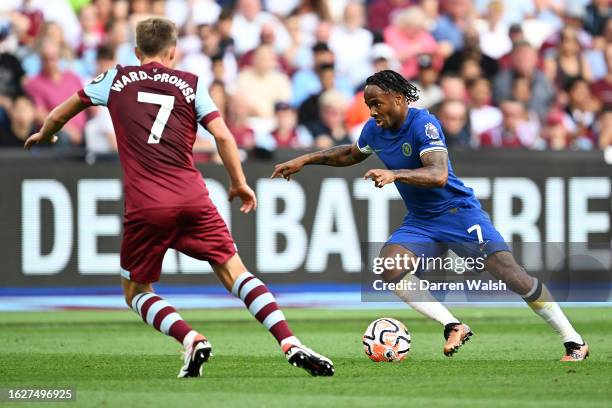 Raheem Sterling of Chelsea runs with the ball whilst under pressure from James Ward-Prowse of West Ham United during the Premier League match between...