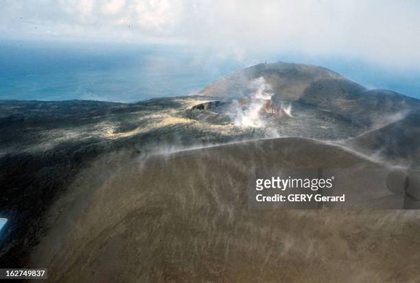 Volcano In Iceland. Islande-1965 - Une de ses îles volcaniques: le Surtsey et ses fumerolles léchant les sommets encerclant le cratère en activité;...