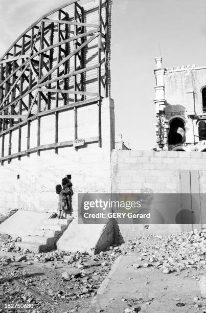 Border Between Israel And Jordan. A Jérusalem, en avril 1963, A la frontière israelo-jordanienne, une fillette regardant à travers le trou du mur...