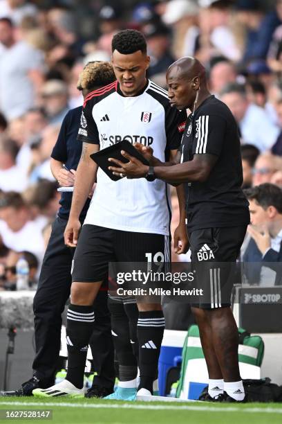 Rodrigo Muniz of Fulham is given instructions by assistant coach Luis Boa Morte during the Premier League match between Fulham FC and Brentford FC at...