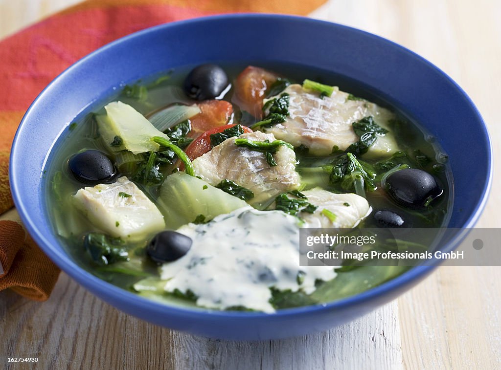 Fish soup with spinach, olives and basil yoghurt