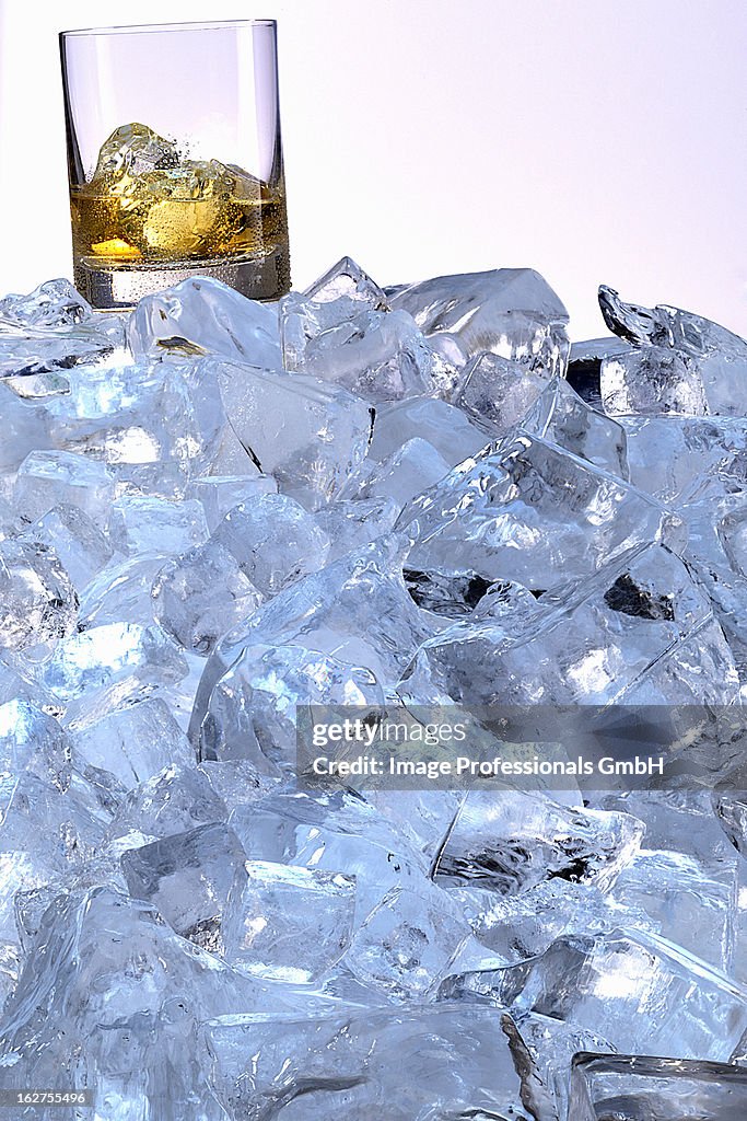 Whiskey glass on mountain of ice cubes