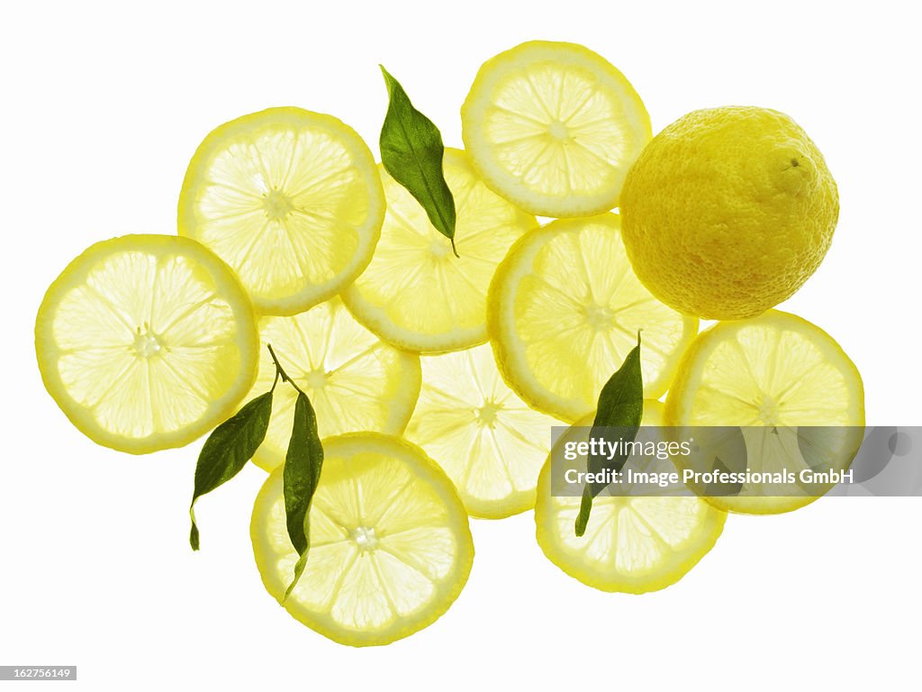 Whole lemon, lemon slices and leaves