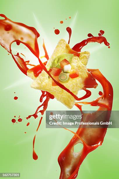 tacos being squirted with tomato sauce against green background - squirting stock pictures, royalty-free photos & images