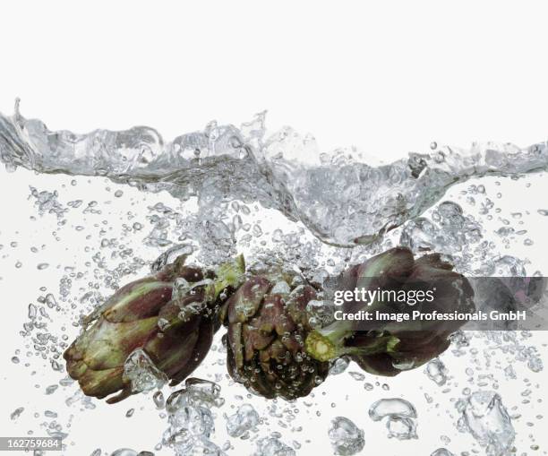 artichokes in boiling water - artichoke stock pictures, royalty-free photos & images