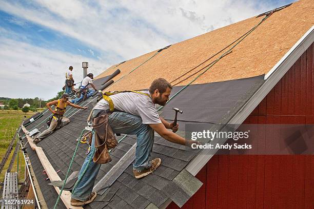 workman install roof on rural building - wasserdicht stock-fotos und bilder