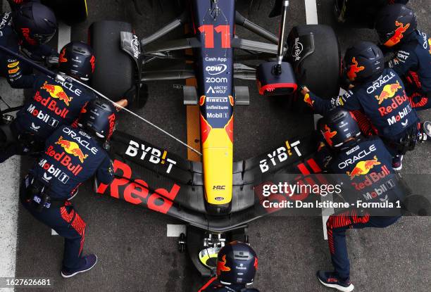 Members of the Oracle Red Bull Racing team work on the car of Sergio Perez of Mexico and Oracle Red Bull Racing during a pit stop in the F1 Grand...