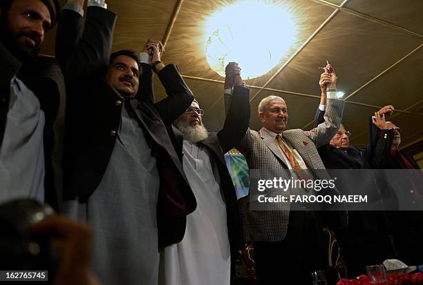 Former Pakistani nuclear scientist and chairman of Tehreek-e-Tahafuz Pakistan party, Abdul Qadeer Khan , raises his hands with Syed Munawar Hassan...