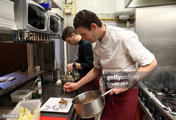 Cooks prepare hachis parmentier de boeuf in the kitchen of a restaurant in Paris, on February 22 AFP PHOTO THOMAS SAMSON