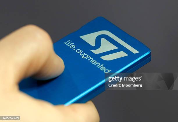 An employee uses an STMicroelectronics NV Mobile Projector device to project an image onto a wall at the Mobile World Congress in Barcelona, Spain,...