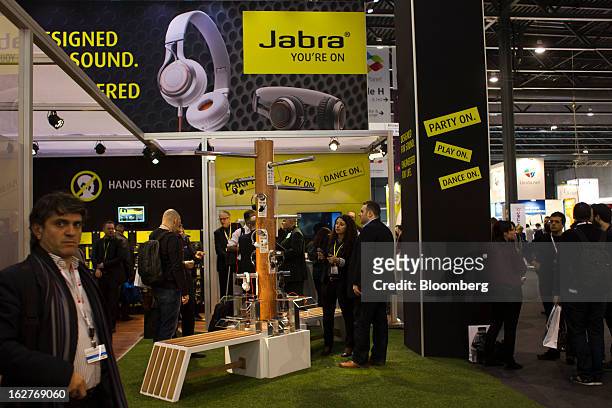 Visitors look at headphone devices on display at the Jabra pavilion at the Mobile World Congress in Barcelona, Spain, on Tuesday, Feb. 26, 2013. The...