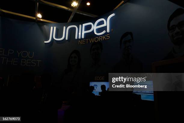 An illuminated sign hangs above the Juniper Networks Inc. Pavilion at the Mobile World Congress in Barcelona, Spain, on Tuesday, Feb. 26, 2013. The...