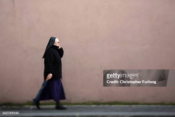 Nun talks on her telephone as she walks next to St Peter's Square on February 26, 2013 in Vatican City, Vatican. The Pontiff will hold his last...