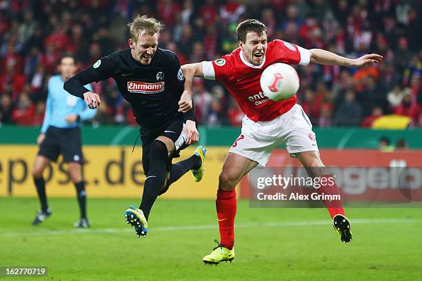 Jan Rosenthal of Freiburg is challenged by Radoslav Zabavnik of Mainz during the DFB Cup Quarter Final match between FSV Mainz 05 and SC Freiburg at...