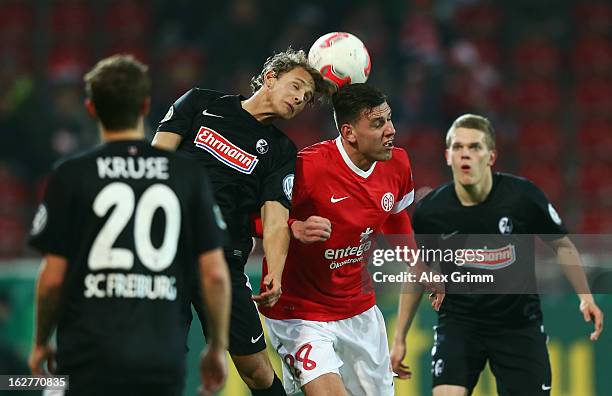 Adam Szalai of Mainz jumps for a header with Vegar Hedenstad of Freiburg during the DFB Cup Quarter Final match between FSV Mainz 05 and SC Freiburg...
