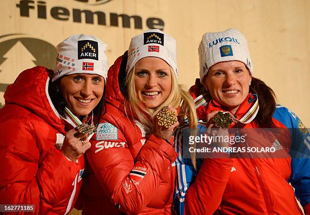 Norway's Therese Johaug poses with her gold medal with silver medalist Marit Bjoergen and bronze medalist Russia's Yulia Tchekaleva on the podium at...