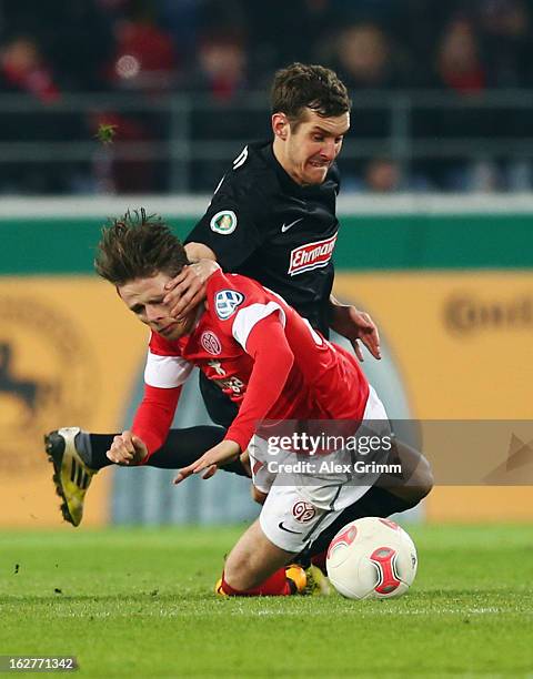 Nicolai Mueller of Mainz is challenged by Julian Schuster of Freiburg during the DFB Cup Quarter Final match between FSV Mainz 05 and SC Freiburg at...