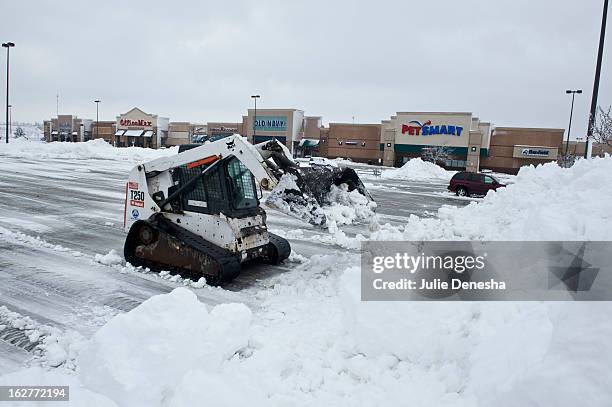 Worker in a Bobcat works to clear snow from a parking lot after a snowstorm hit the midwest February 26, 2013 in Merriam, Kansas. This is the second...