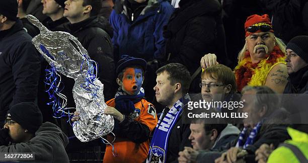 An Oldham fan holds a replica FA Cup before before the start of the English FA Cup fifth round replay football match between Everton and Oldham...