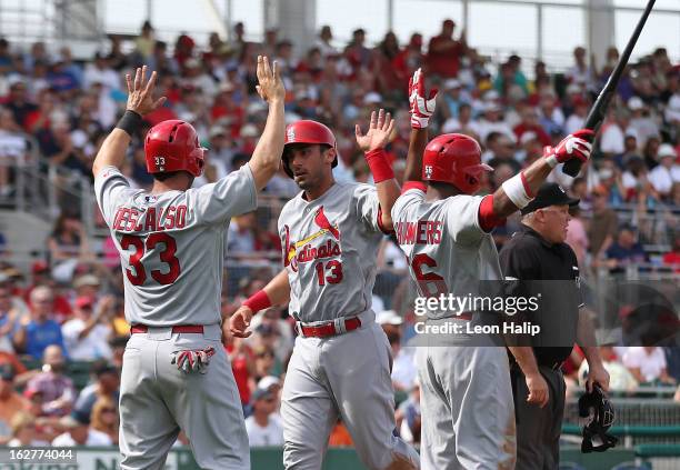 Adron Chambers, Daniel Descalso and Matt Carpenter of the St. Louis Cardinals celebrate after scoring on a double to center field from Tony Cruz...