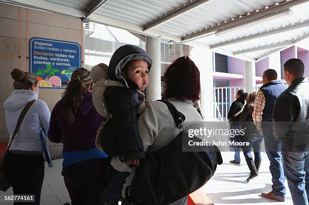 People wait to cross from Mexico into the United States at the DeConcini port of entry on February 26, 2013 in Nogales, Arizona. Some 15,000 people...