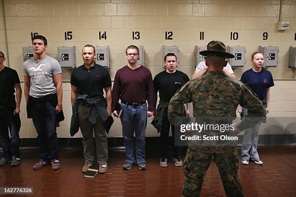 Tara Ratterree of Catlettsburg, Kentucky waits with male Marine recruits for a drill instructor’s orders to call home shortly after arriving at boot...