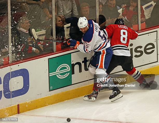 Nick Leddy of the Chicago Blackhawks crashes into Ben Eager of the Edmonton Oilers at the United Center on February 25, 2013 in Chicago, Illinois....