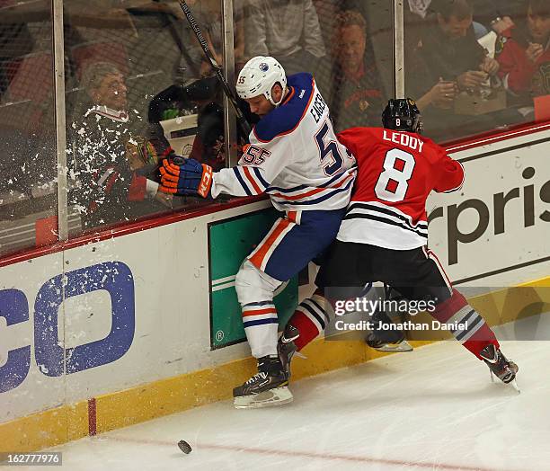 Nick Leddy of the Chicago Blackhawks crashes into Ben Eager of the Edmonton Oilers at the United Center on February 25, 2013 in Chicago, Illinois....