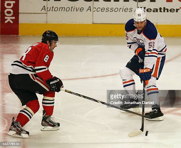 Ben Eager of the Edmonton Oilers controls the puck next to Nick Leddy of the Chicago Blackhawks at the United Center on February 25, 2013 in Chicago,...
