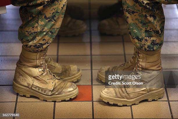 Female Marine recruits sit with their feet at a 45 degree angle, the same angle they are at while standing at the position of attention, while having...