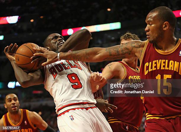 Loul Deng of the Chicago Bulls tries to control the ball under pressure from Marreese Speights and Luke Walton of the Cleveland Cavaliers at the...