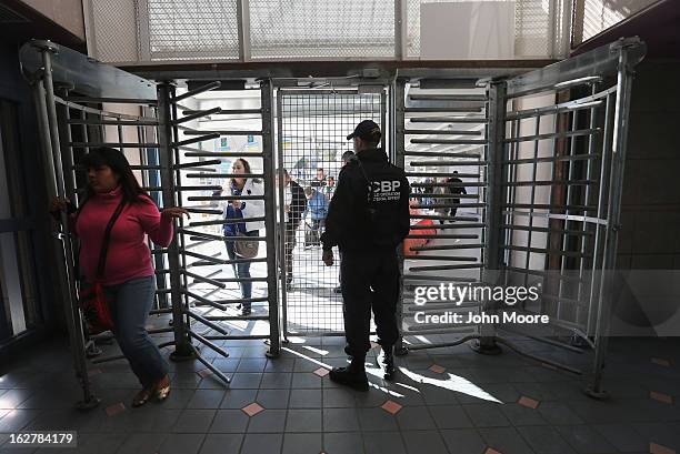 Customs and Border Protection officer from the Office of Field Operations , watches as people cross from Mexico into the United States on February...