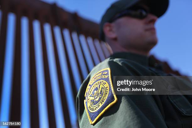 Border Patrol agent stands at the U.S.-Mexico border fence on February 26, 2013 in Nogales, Arizona. Various federal agencies are tasked with...