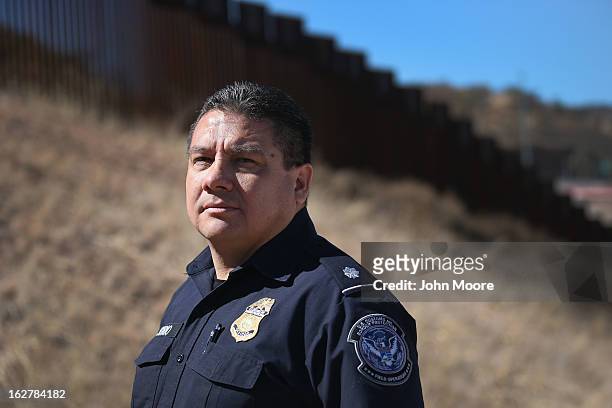 Juan Osorio from the U.S. Office of Field Operations , stands near the U.S.-Mexico border fence on February 26, 2013 in Nogales, Arizona. Some 15,000...