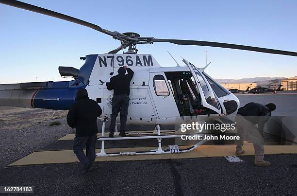 Officers from the U.S. Office of Air and Marine prepare a helicopter for an aerial patrol on February 26, 2013 in Tucson, Arizona. The U.S. Customs...